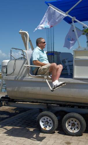 Capt. Tim Lippoldt is hoisted aboard his new boat, the specially-adapted ICAN, Thursday, June 2, 2022, at Jim’s Pier on South Padre Island. (Rick Kelley/Valley Morning Star)