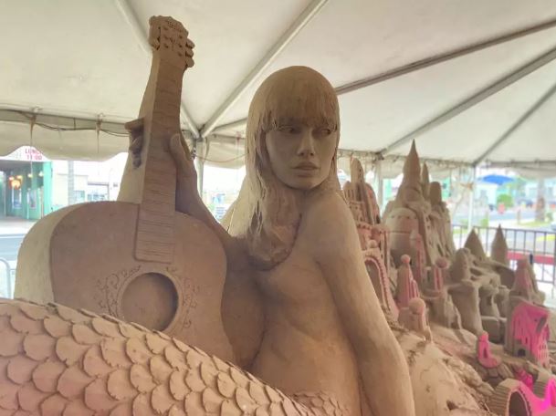 Mermaid Taylor Swift holding guitar at Holiday Sandcastle Village of South Padre.