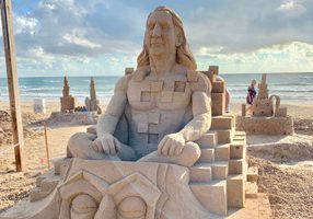 Sand sculpture of a man sitting on a throne